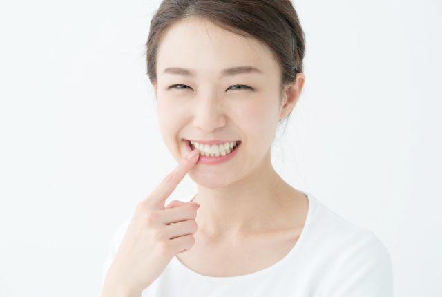 白い歯を見せて微笑む女性